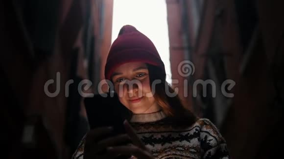 一个女人站在街上看着手机屏幕视频的预览图