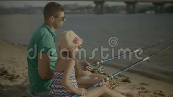 父亲和可爱的女孩在河边钓鱼视频的预览图