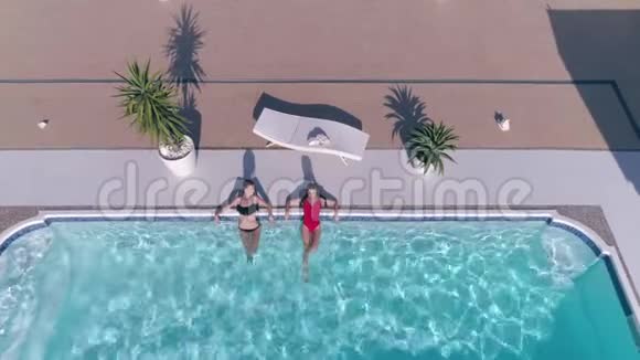 穿泳装的可爱的女朋友暑假正在游泳池里休息视频的预览图