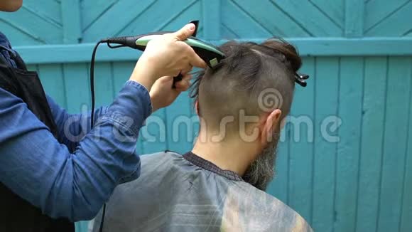在露天理发店的理发过程中用电动剃刀剪头男士剪头视频的预览图