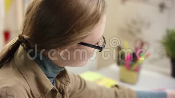 年轻漂亮的女学生在读书时用笔记本写字视频的预览图