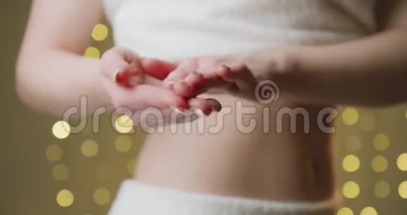 年轻女孩涂奶油腰部和腹部视频的预览图