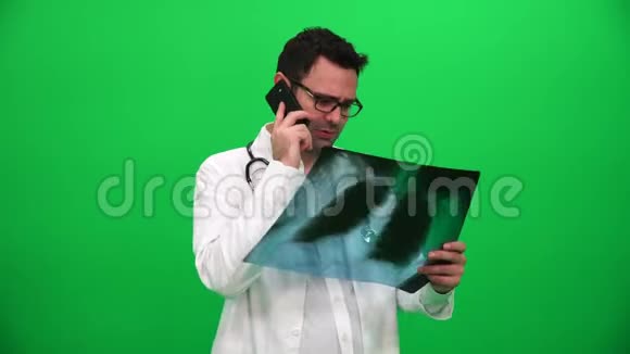 医生拿着X光检查结果在绿色屏幕上打电话视频的预览图