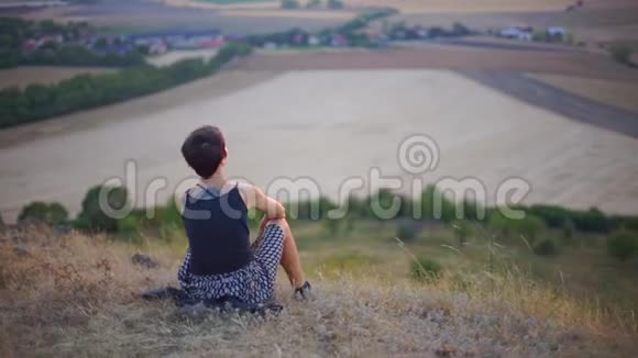 女孩坐在山上望着远处视频的预览图