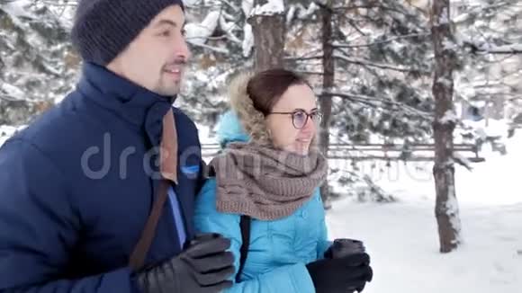 两个年轻人在清新的空气中在浪漫的雪地氛围中相遇喝咖啡亲吻视频的预览图