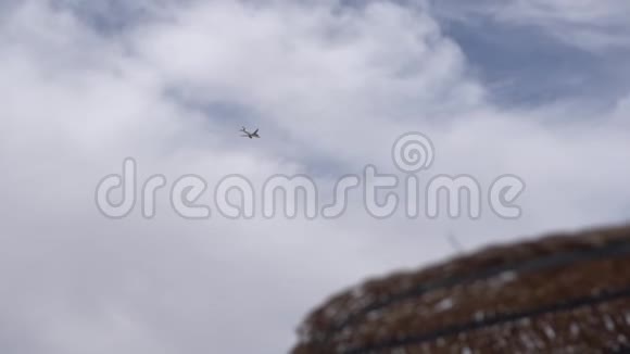 飞机飞行在背景和前景海滩伞偏离焦点视频的预览图