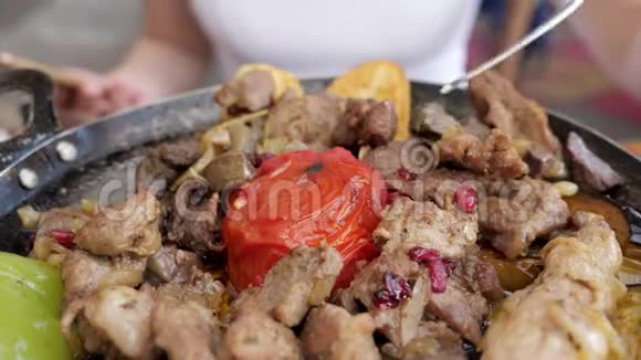 女人吃肉和蔬菜在煎锅在餐厅特写视频的预览图