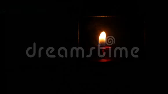 一支燃烧着美丽的红色圆形祈祷蜡烛在天主教教堂黑暗中的一个特殊位置视频的预览图