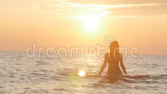 一个女人在黎明时穿着泳衣从水中出来一个女孩在海里游泳享受日出骗局视频的预览图