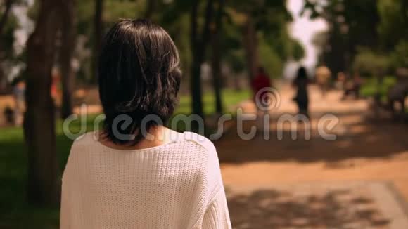 一个女人在公园散步的背景视频的预览图