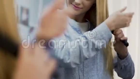 女孩梳着柔软的金发用洗发水和护肤霜化妆品视频的预览图