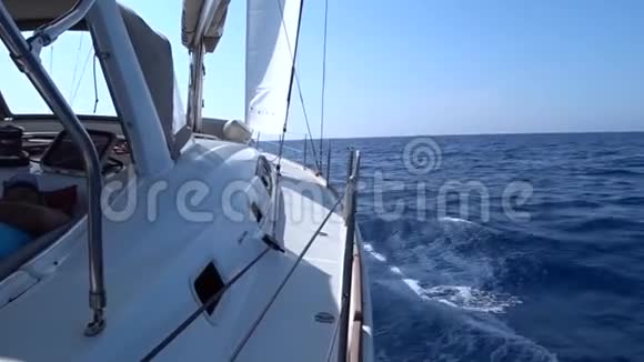 从游艇甲板到船头和帆特写蓝色的大海和波浪的Side视图视频的预览图