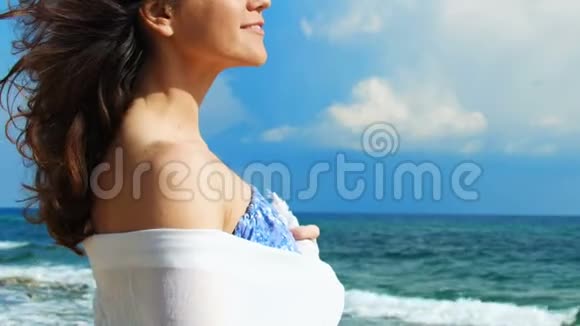 快乐的年轻黑发女人在海滩上看地平线享受风景放松视频的预览图