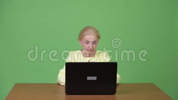 漂亮快乐的高级女商人用笔记本电脑获取好消息视频的预览图