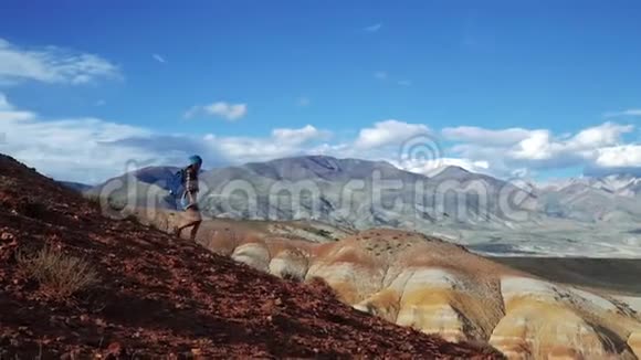 年轻的旅游妇女带着背包和帽子从红石山下来不真实的风景和视频的预览图
