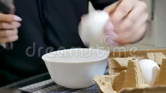 女性手的视频是用刀子把鸡蛋切成白色陶瓷碗视频的预览图