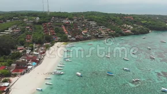 海岸JungutBatu村有船只和酒店在伦本甘岛印度尼西亚空中观景视频的预览图