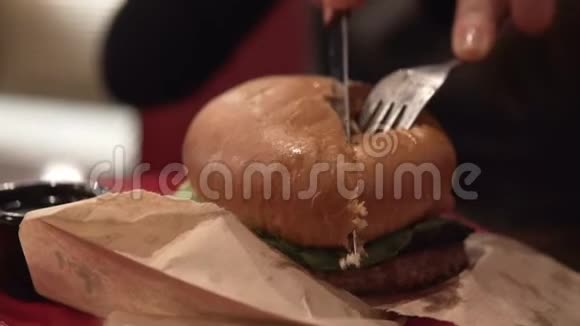 女性手切一大块多汁的牛肉汉堡视频的预览图