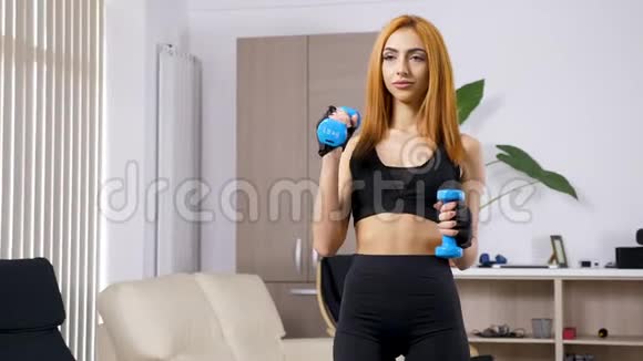 在她的客厅里近距离锻炼身体的年轻女子视频的预览图