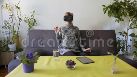 家里的女人害怕在沙发上用虚拟现实护目镜视频的预览图