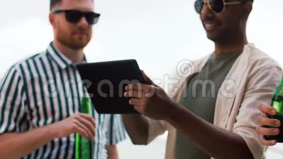 有平板电脑的男人在屋顶喝啤酒视频的预览图