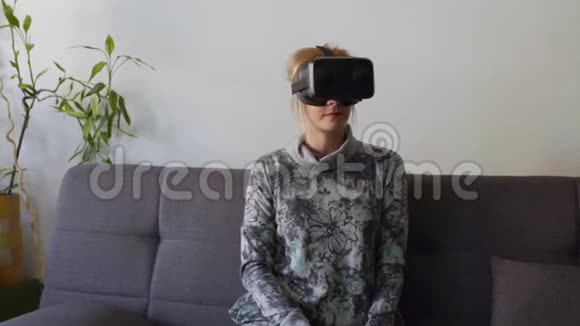 家里的女人害怕在沙发上用虚拟现实护目镜视频的预览图