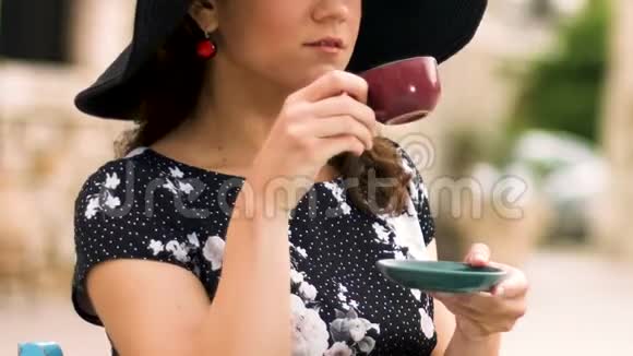 戴帽子的聪明女人在街头咖啡馆喝咖啡享受假期视频的预览图