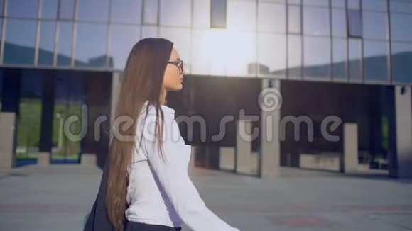 年轻成功女商人或女学生穿着现代西装穿着白色衬衫走在路上的女性的侧视视频的预览图