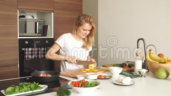 幸福的女妻子穿着白色t恤在厨房做饭的肖像视频的预览图