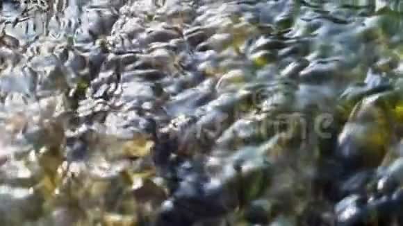 缓慢流动的水的模糊背景耀眼的光线反射在河底视频的预览图