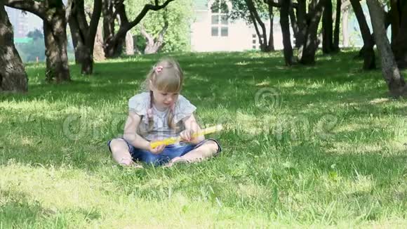 漂亮的小女孩在花园里吹肥皂泡视频的预览图