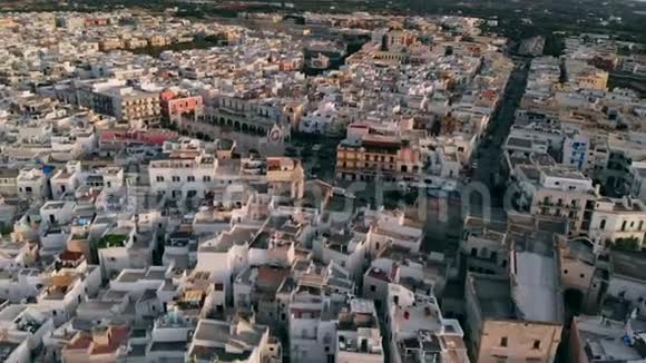 在日落时分飞过意大利城市波利尼亚诺的屋顶阿普利亚视频的预览图