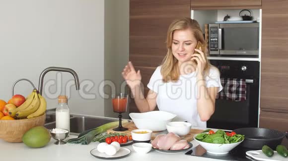 幸福的女妻子穿着白色t恤在厨房做饭的肖像视频的预览图