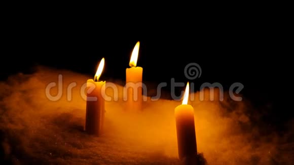 蜡烛在雪中燃烧在黑暗的背景下蜡烛结束去冥想项目视频的预览图