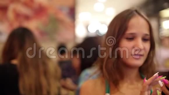 年轻的美女在咖啡馆喝葡萄酒并使用手机在bokeh灯的背景1920x1080视频的预览图
