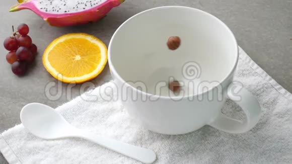 在桌子上的杯子里倒入巧克力麦片球健康的早餐概念视频的预览图