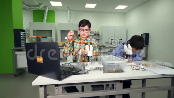 小男孩在学校实验室做化学生物实验视频的预览图