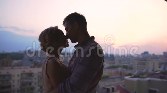 情侣们温柔地接吻在多层楼的屋顶上度过浪漫的约会视频的预览图