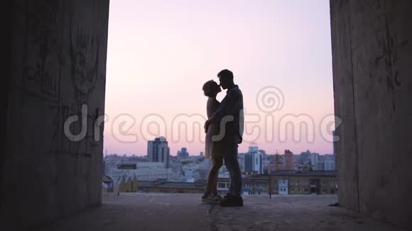 在地平线上夕阳的背景下拥抱恋人的剪影浪漫视频的预览图