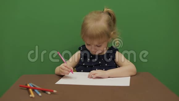 女孩在桌子边画画教育进程那个女孩有个好主意快乐的三岁女孩可爱的女孩微笑视频的预览图