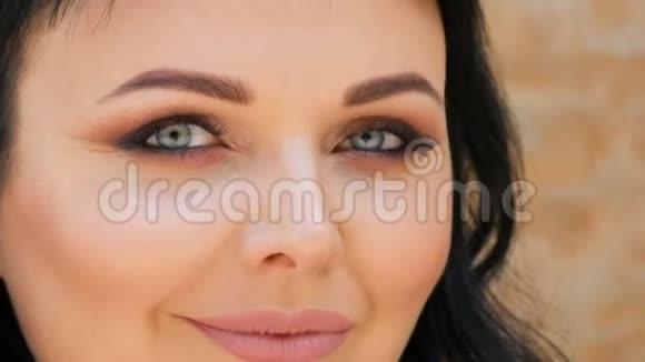 一个非常漂亮的蓝眼睛女模特的肖像留着长长的黑发和美丽的晚妆摆在面前视频的预览图