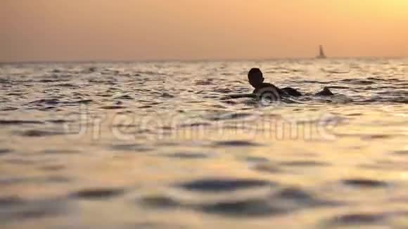带冲浪板的青少年在海浪的背景下完全高清慢动作视频的预览图