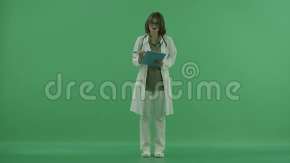 女医生看着摄像机把文件写在绿色屏幕上视频的预览图