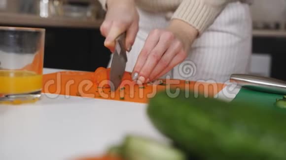 一对年轻夫妇正在厨房里做午饭用男性的手拢并移动就是切切片番茄视频的预览图