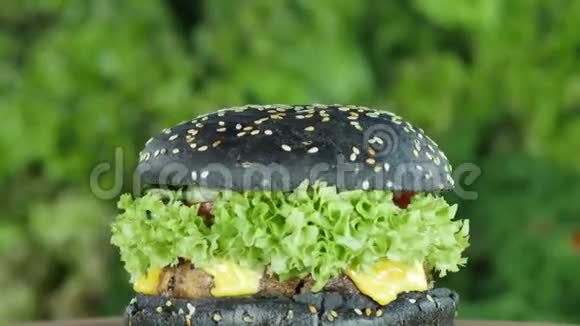 奶酪汉堡或牛肉黄瓜和黑色面包在模糊的背景上旋转一圈视频的预览图