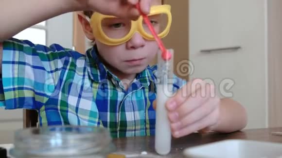 家庭化学实验令人惊讶的男孩看着试验中气体释放的化学反应视频的预览图
