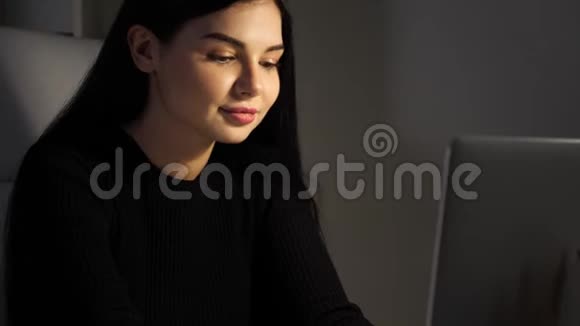 在办公室的女商人在她的笔记本电脑上打字然后微笑晚上好视频的预览图