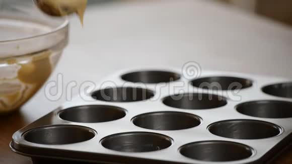 准备烤松饼面团分成纸杯和一块巧克力棒松饼烘焙的特写视频的预览图