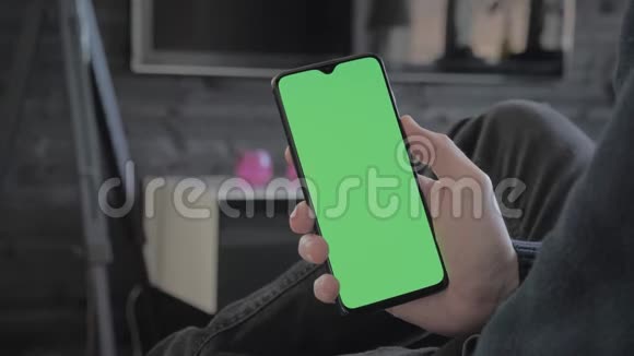 绿色屏幕一个男人在客厅里看着一部智能手机然后刷卡视频的预览图