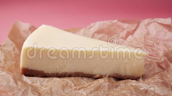 在食品包装纸上丢失一片新鲜的传统奶酪蛋糕框架孤立于粉红色视频的预览图